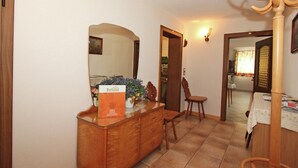 Un comedor con una mesa de buffet de madera, una silla y un espejo que refleja la habitación.