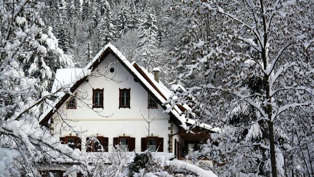 A traditional chalet with a symmetrical facade, multiple windows, and a steeply pitched roof, surrounded by snow-covered trees. - Holiday Home in Hermagor near Nassfeld Ski Area (Hermagor)