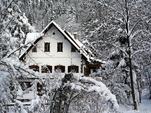 A traditional chalet with a symmetrical facade, multiple windows, and a steeply pitched roof, surrounded by snow-covered trees. - Holiday Home in Hermagor near Nassfeld Ski Area (Hermagor)