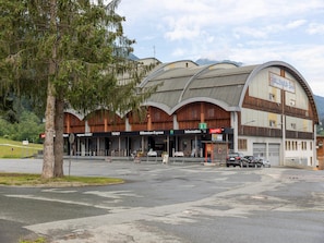A building with a curved roof and multiple entrances, including a ticket booth and a depot.