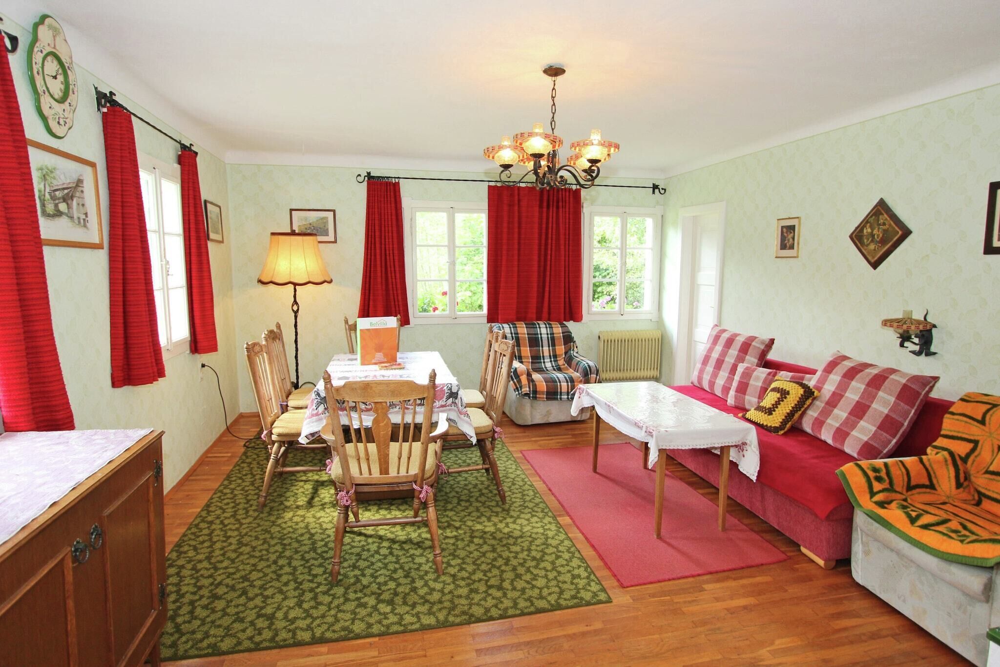 A cozy living room with a dining table, chairs, a sofa, and a coffee table.