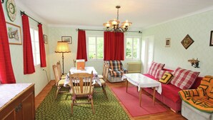 A cozy living room with a dining table, chairs, a sofa, and a coffee table.