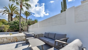 An outdoor patio with a sofa, chairs, and a table.