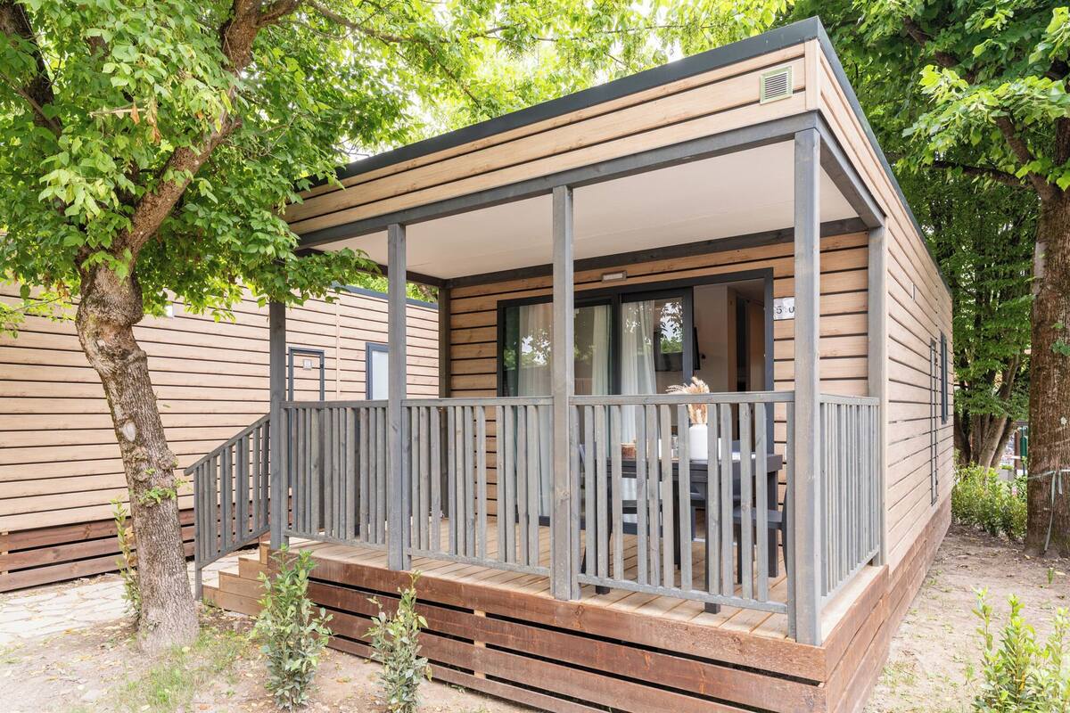 A small wooden cabin with a porch, a window, and a door.