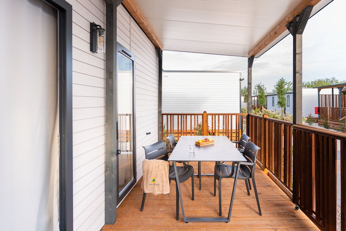 Une terrasse extérieure avec une table et des chaises, une terrasse en bois et une vue sur les environs.