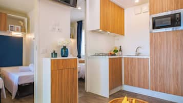 Full-sized fridge, stovetop, cookware/dishes/utensils, dining tables