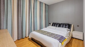 A modern bedroom with a bed, curtains, a bedside table, and a nightstand. - Kunming Panju Hotel (Kunming)