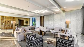 A spacious living area with a pool table, sofas, and a coffee table.