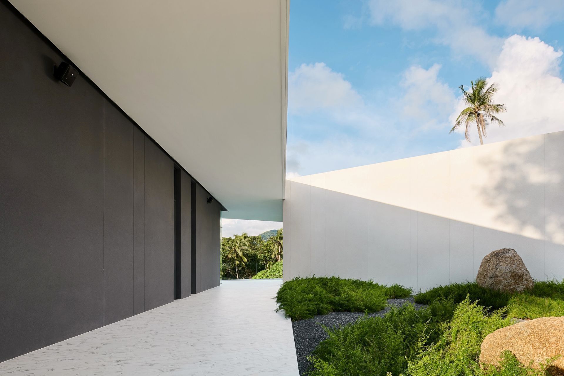 A modern building with a minimalist design, featuring a clean, white exterior and a flat roof.