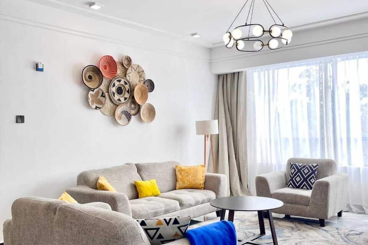 Una sala de estar moderna con un sofá gris, una mesa de centro redonda y un tapete estampado.