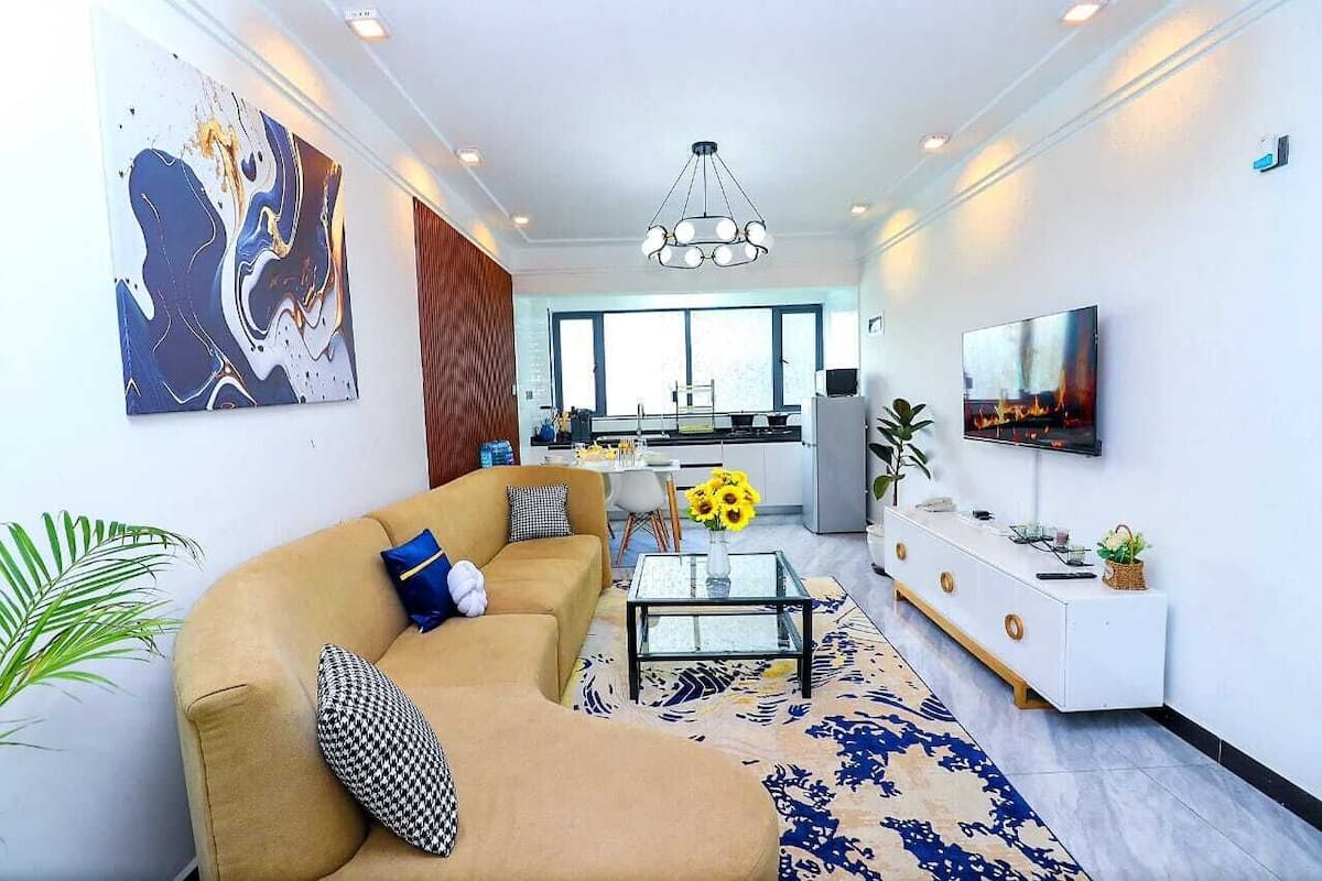 Una sala de estar moderna con un sofá, una mesa de centro y un televisor.