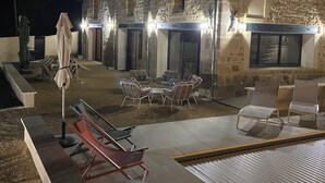 Un bâtiment en pierre doté d’une terrasse et de parasols.