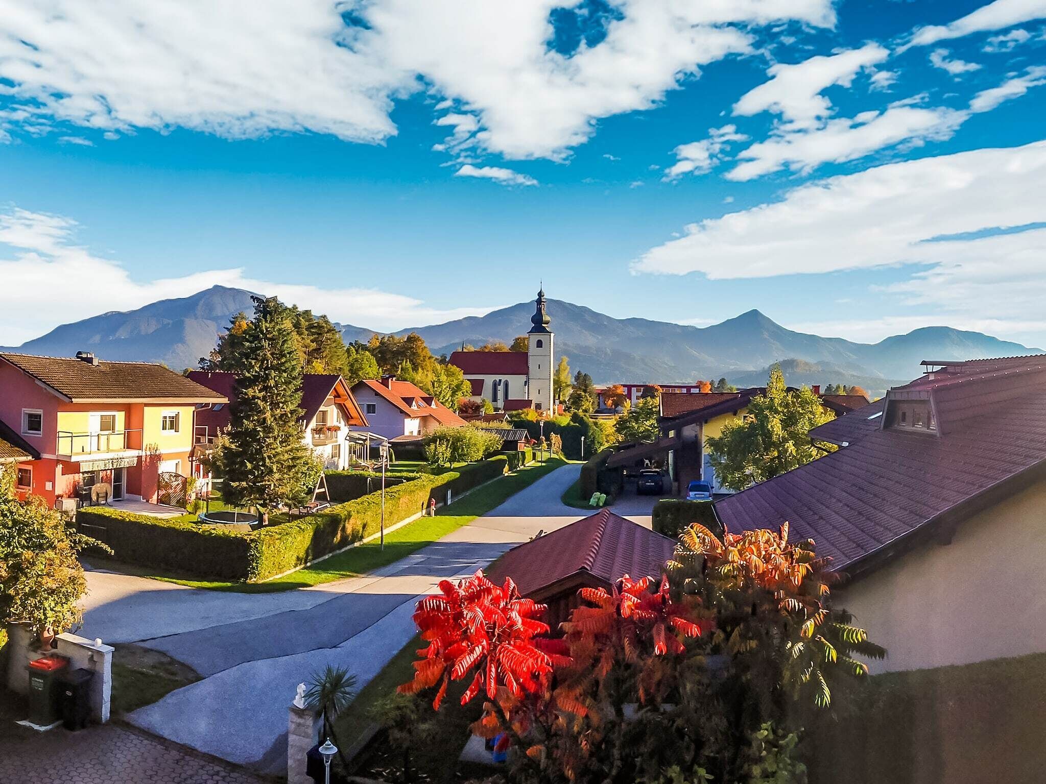 A town with a prominent church, residential buildings, and a mountain backdrop.