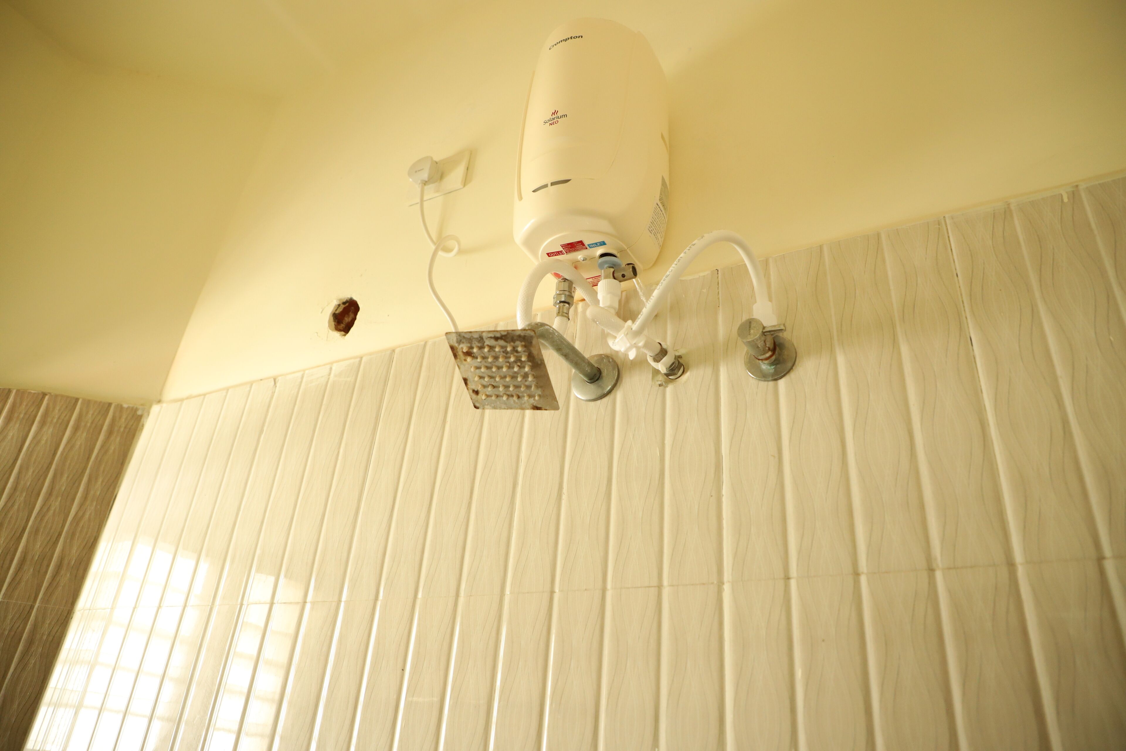 Ein Badezimmer mit Dusche, Handtuchhalter und Wandheizung.