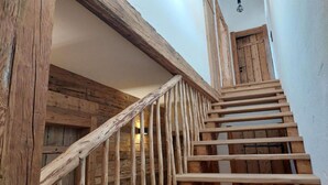 En trappe i træ med et rustikt design, der fører op til en dør.