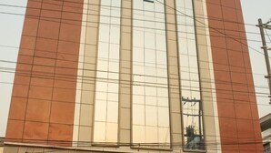 A hotel named Vista Suites with a modern facade, large windows, and a visible entrance. - Hotel Vista Suites (Tezpur)