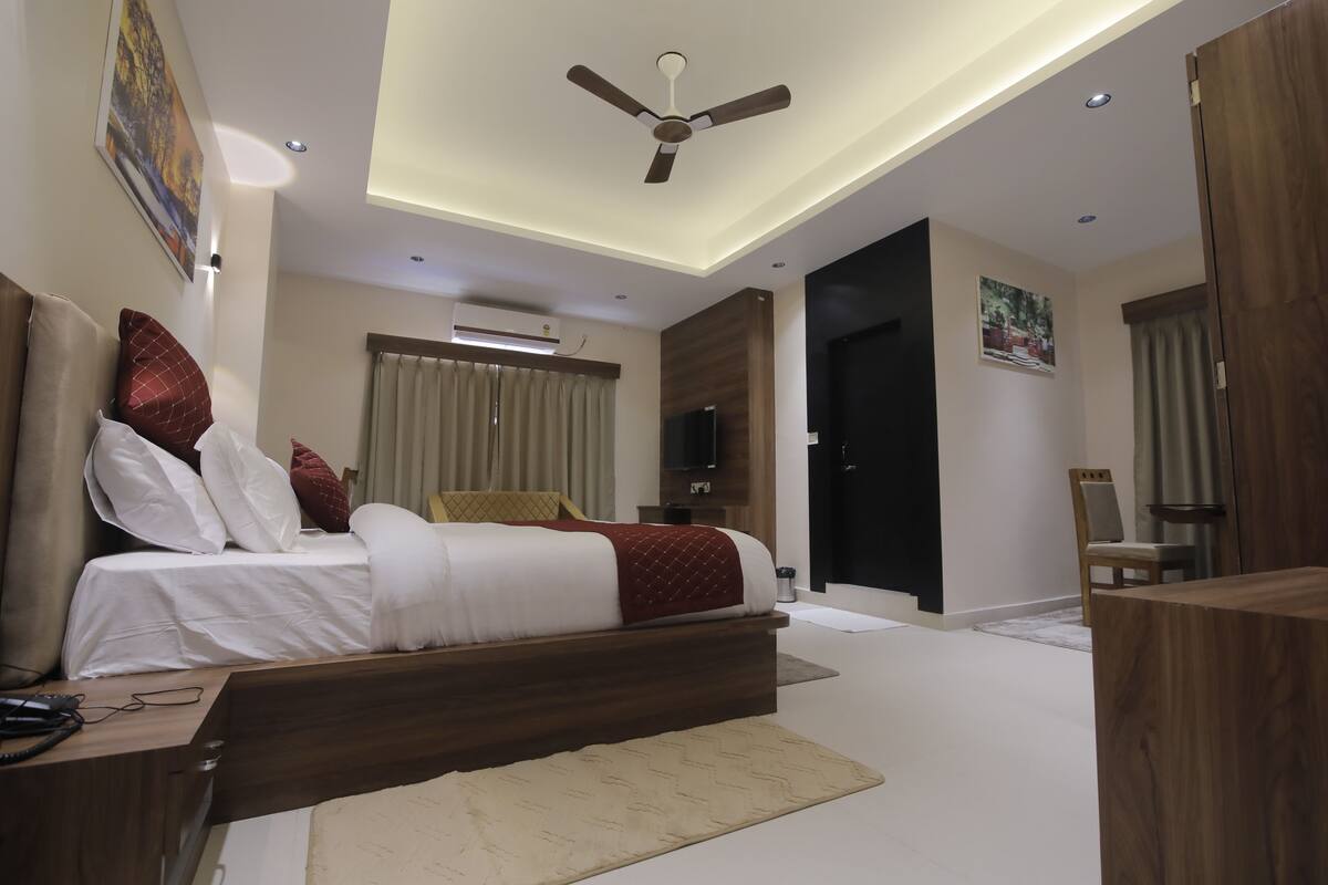 Una camera da letto moderna con un letto grande, un ventilatore a soffitto, un condizionatore d'aria e una televisione.