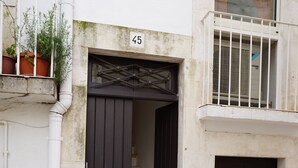 A building with a dark brown door, a white number '45' above it, and a small set of stone steps leading up to the entrance. - Heart of Puglia - Design Apartment in Puglia with 2 bedrooms (Putignano)