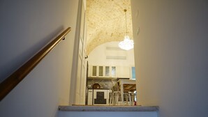 A staircase leading to a room with a stone ceiling and a chandelier. - Heart of Puglia - Design Apartment in Puglia with 2 bedrooms (Putignano)