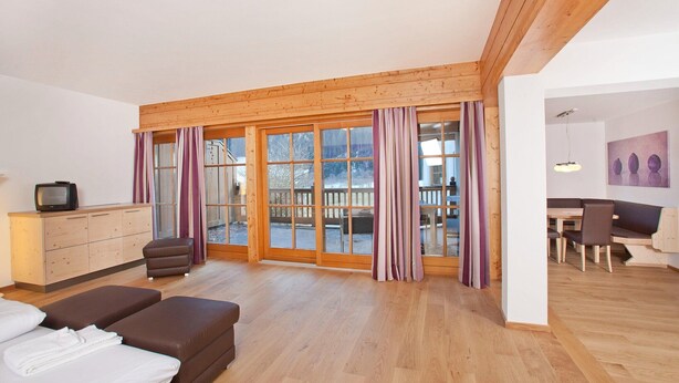 A room with a wooden ceiling, a TV on a cabinet, a sofa, and a dining area with chairs and a table. - Chalet in Pinzgau near Ski Slopes (Wald im Pinzgau)