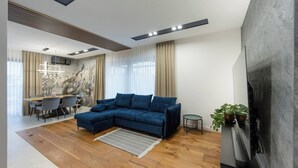 Un salon moderne comprenant un canapé d’angle, un coin repas et une cheminée.