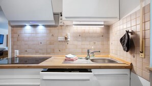 Cozinha com bancada de madeira, pia e máquina de lavar louça.