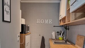 Una cocina moderna con encimera de madera, armarios empotrados y un cartel con la palabra 'HOME'.