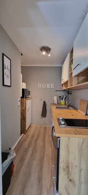 Una cocina moderna con encimera de madera, armarios empotrados y un cartel con la palabra 'HOME'.