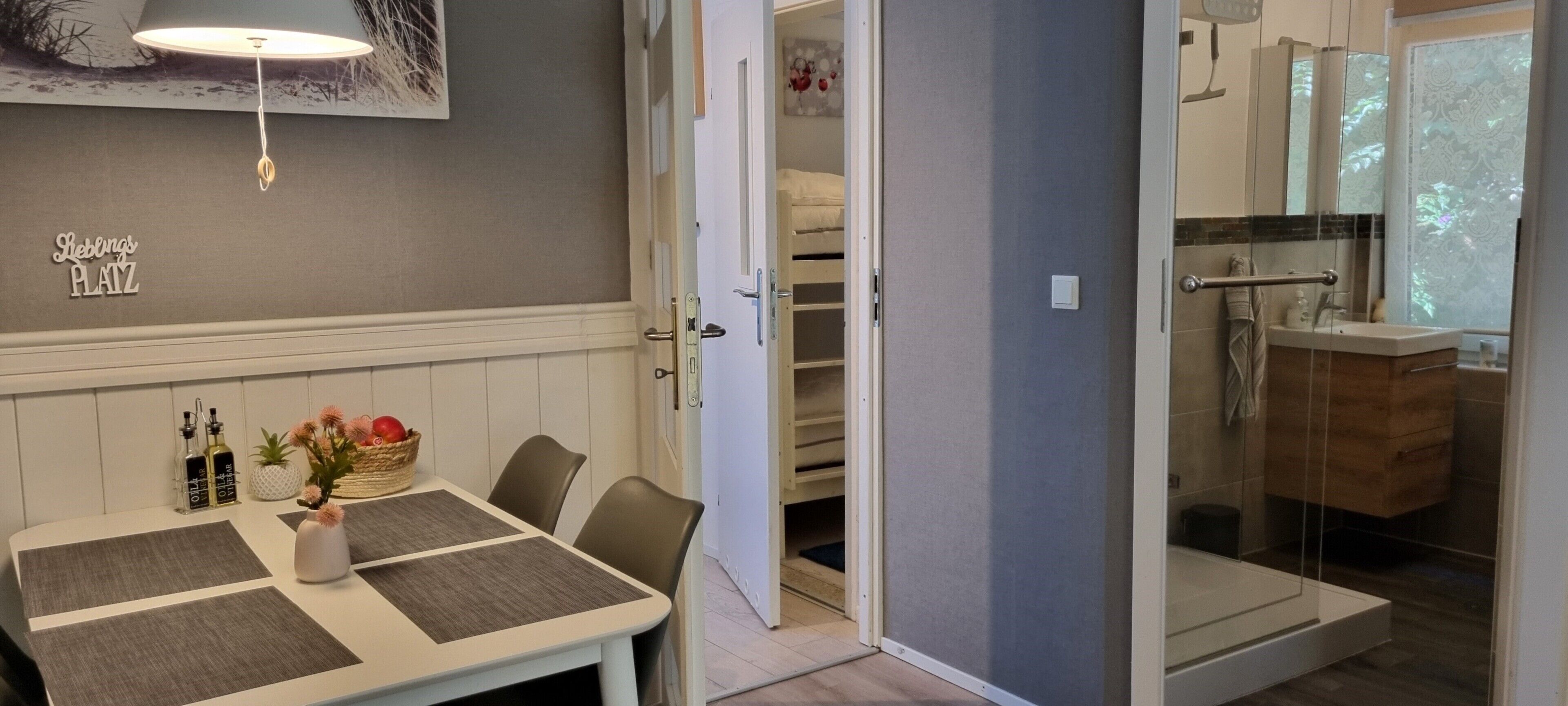 Una camera d'albergo con zona pranzo, cabina doccia e un letto.