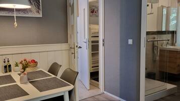 Una camera d'albergo con zona pranzo, cabina doccia e un letto.