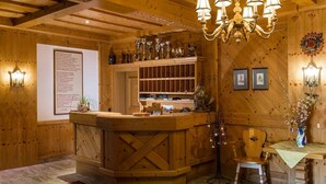 A wooden interior with a reception desk, chandelier, framed pictures, and trophies on shelves. - Apartment in Radstadt near Ski Amadé (Radstadt)