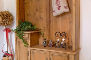 Un meuble en bois sur lequel sont posés une plante, deux ours en peluche et un chandelier.