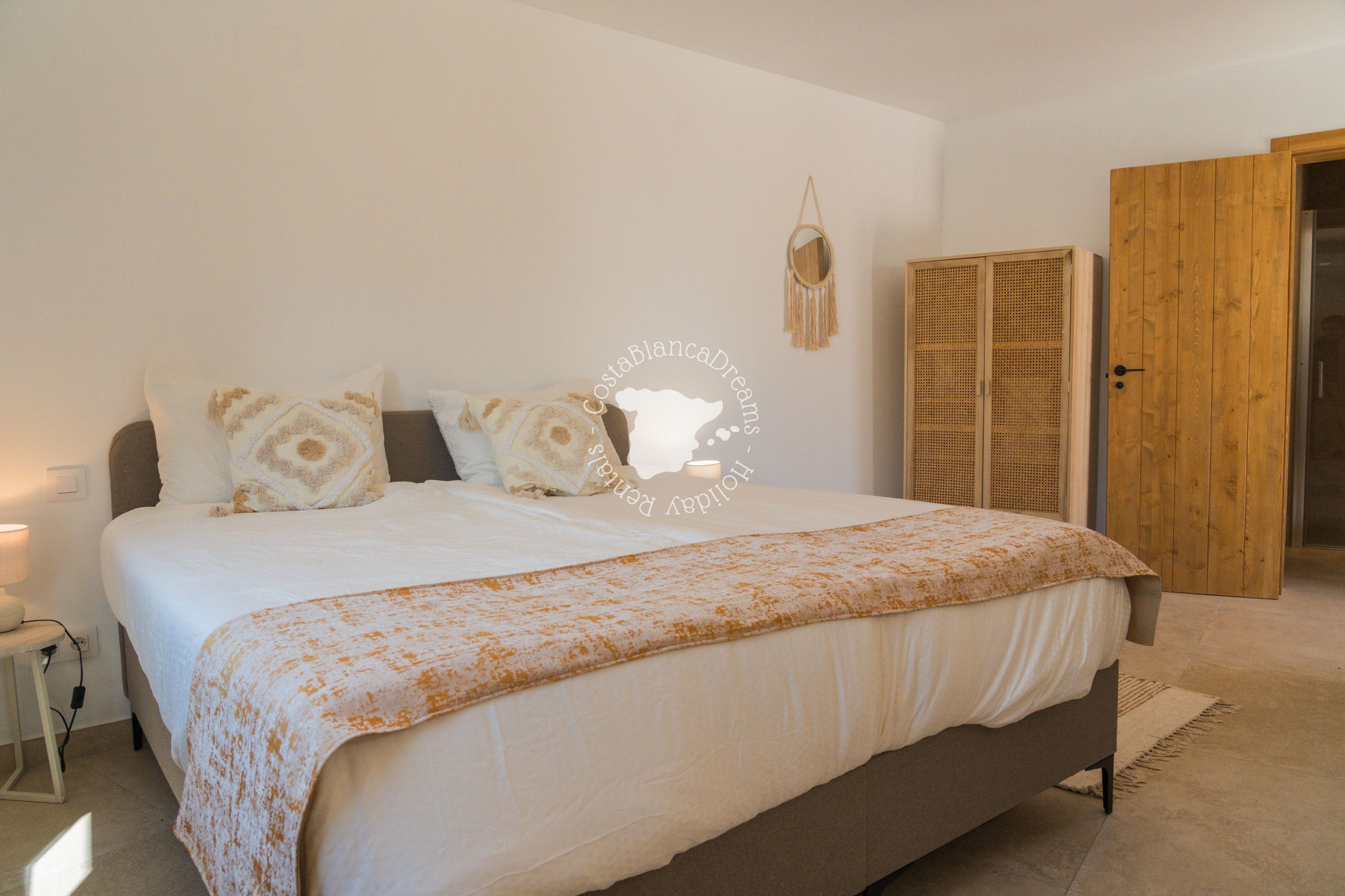 Une chambre à coucher avec un lit, une table de chevet et une armoire.