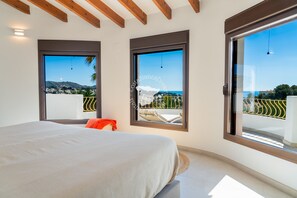 A bedroom with a bed, a window, and a view of a balcony with chairs and a table. - CostaBlancaDreams - Casa Fuente Salvaje in Moraira (Moraira)