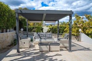 A covered outdoor seating area with wicker furniture and a pergola structure. - CostaBlancaDreams - Casa Monica in Calpe (Calpe)