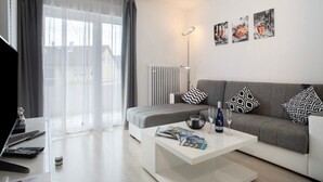 A modern living room with a sofa, coffee table, and artwork on the wall.