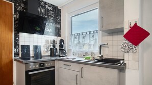 A modern kitchen with a built-in oven, a coffee maker, and a window with a view.