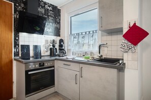 Een koelkast, een oven, een kookplaat, een koffiezetapparaat/waterkoker