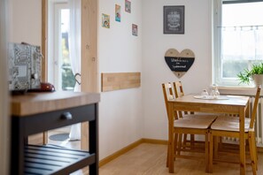 Un coin repas avec une table et des chaises en bois, une fenêtre donnant sur un paysage agréable et des éléments décoratifs sur les murs.