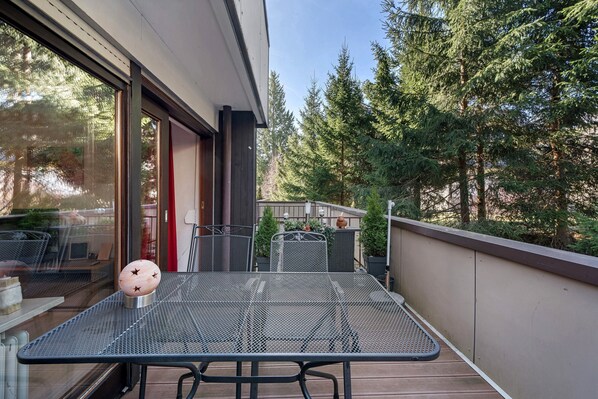 A balcony with a metal table, chairs, and a potted plant. - Apartment '101 Luisa' with Mountain View, Balcony and Wi-Fi (Schönwald im Schwarzwald)