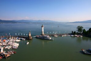 A harbor with boats, a lighthouse, and a pier. - Apartment 'Kaufmannshaus' with Wi-Fi (Lindau am Bodensee)
