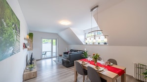 Un appartement moderne de style « loft », comprenant un coin repas, un salon et un escalier.