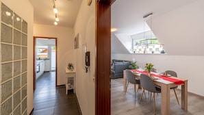 Une cuisine moderne avec un coin repas, un escalier et une vue sur l’extérieur.