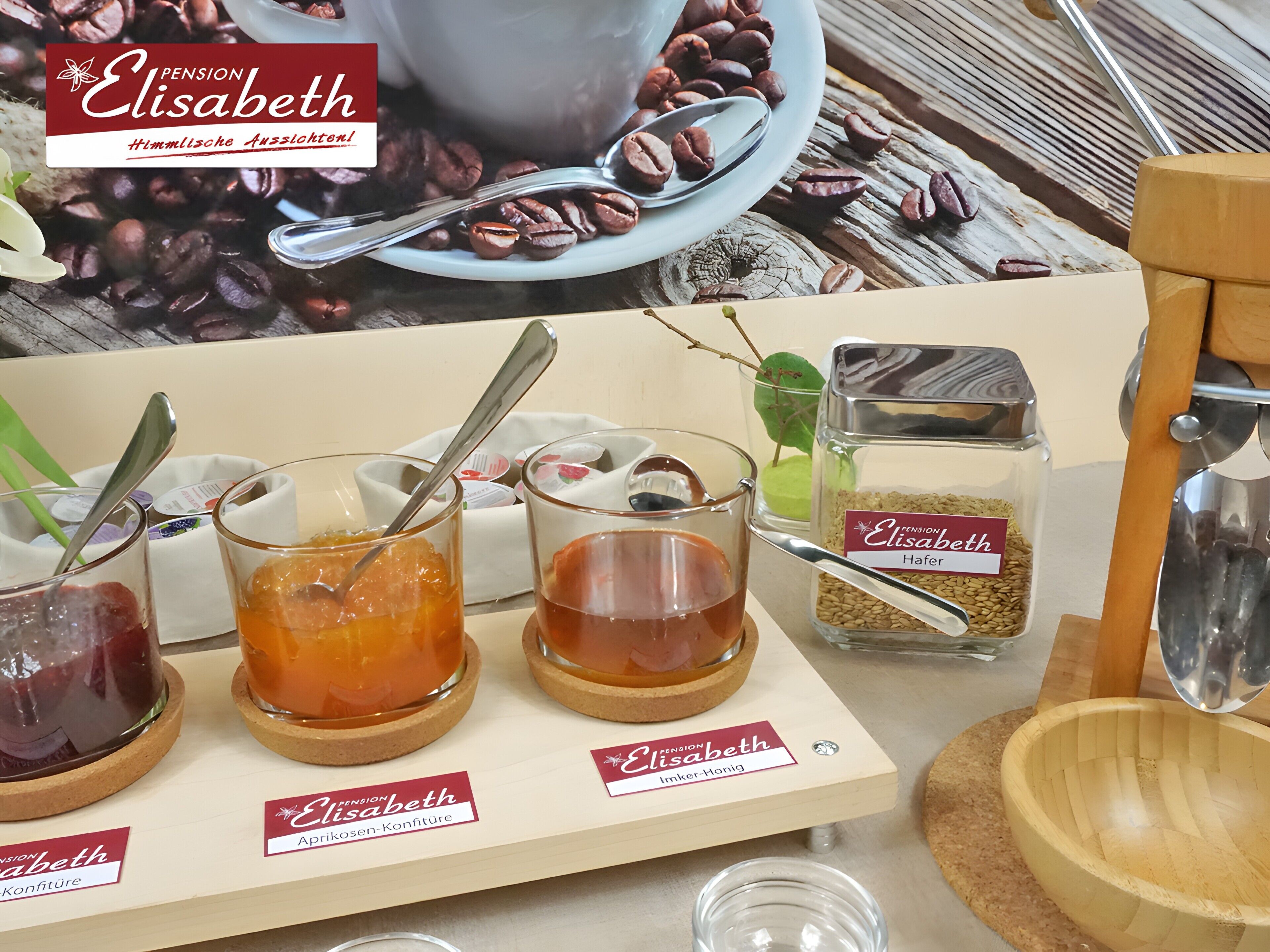 Uma mesa com diversos alimentos e uma xícara de café, identificada com 'Pension Elisabeth'.
