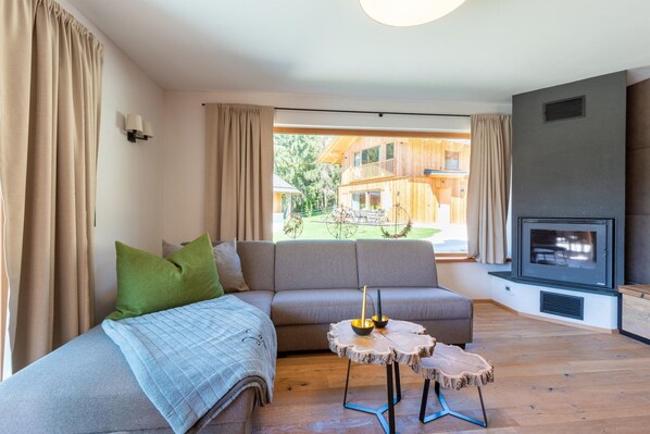 Una sala moderna con un sofá, una mesita redonda y una chimenea.