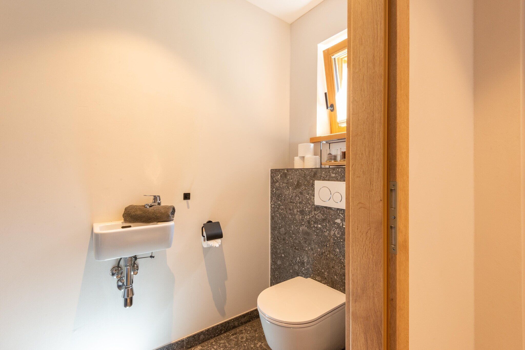 A small bathroom with a white sink, a toilet, and a mirror above the sink.