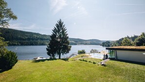 A lakeside property with a modern building, a swimming pool, and a dock. - Pension Elisabeth Double Room No. 3 with Breakfast Included (Todtnau)