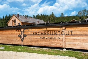 A wooden building with the text "Lerchpeuntgut Almchalet" on its side. - Pleasant chalet in Wölting with sauna (Wölting)