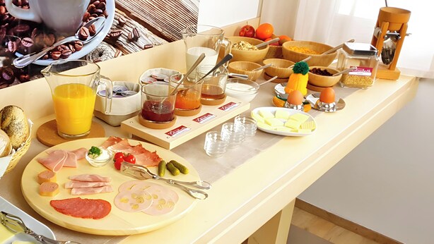 Un bufé de desayuno con diversos alimentos y acompañamientos.