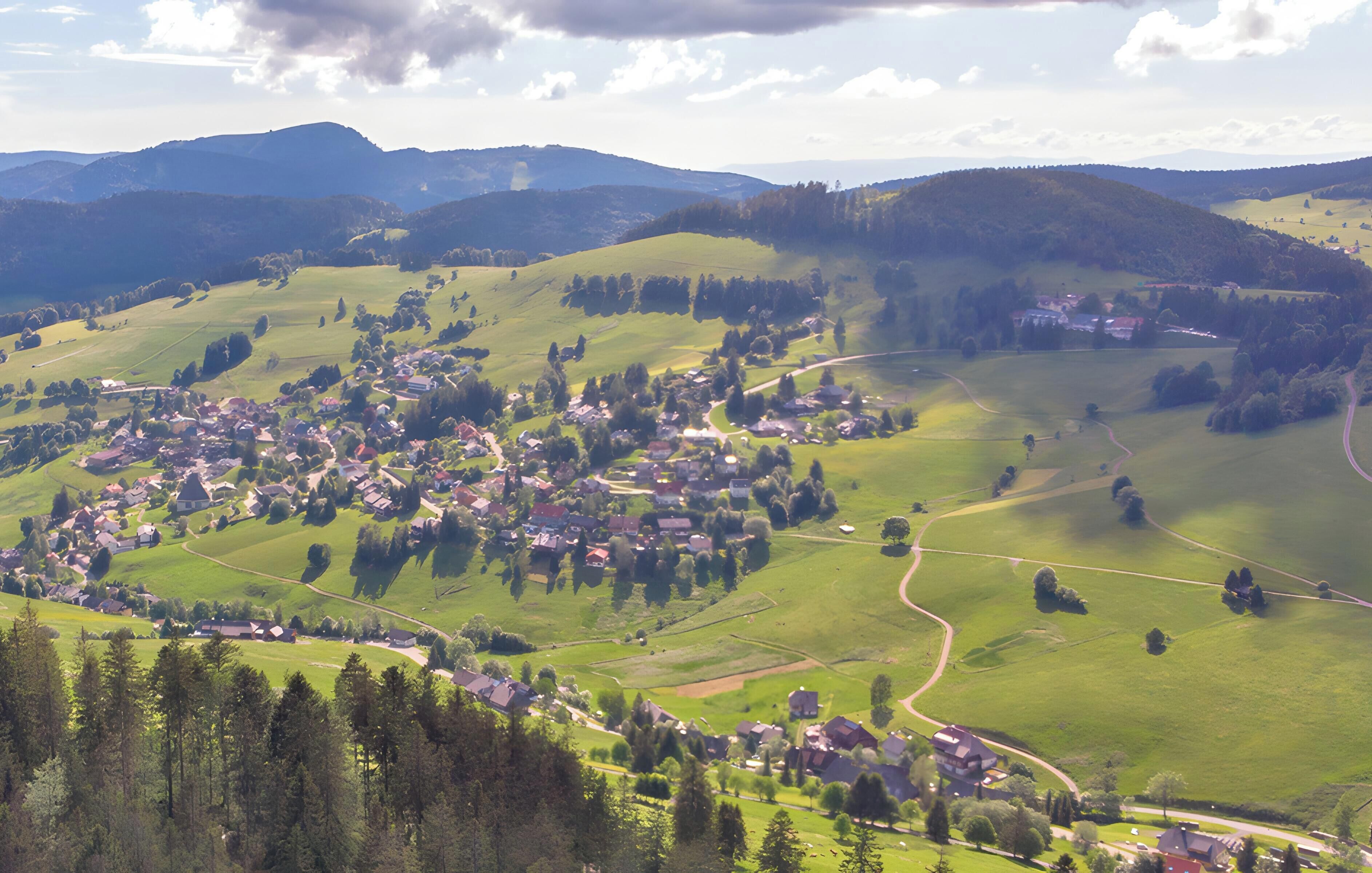 A rural village with houses, roads, and surrounding greenery.